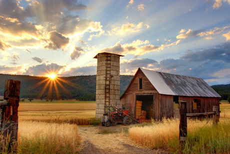 Barn in field with setting sun